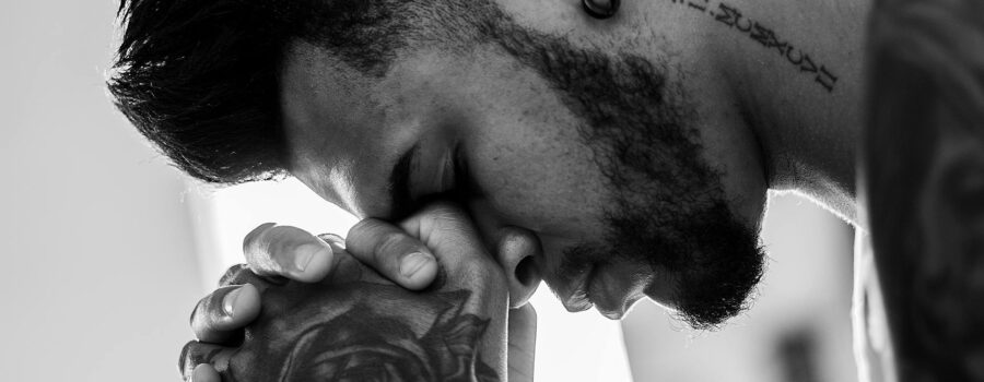man tattooed praying