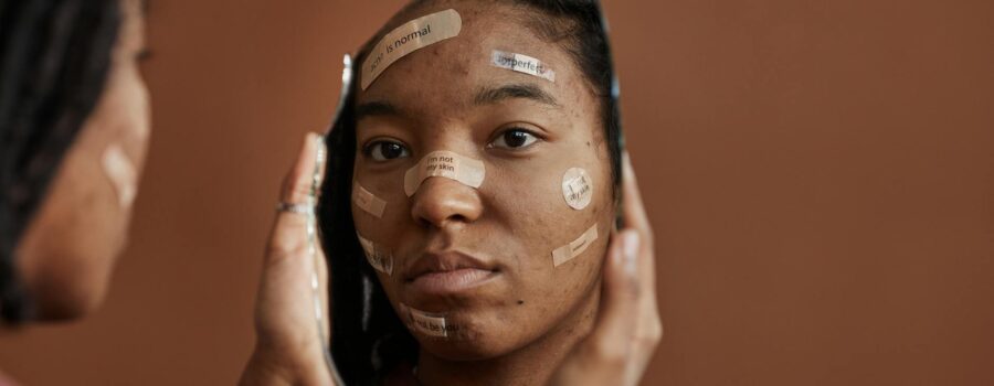 a sad woman looking at herself on a broken mirror she is holding